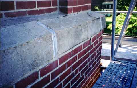 Photograph showing how the whole wall above the sidewalk south of the front door of the church was about to slough off.