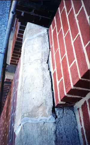 Photograph of wide gap letting water flow into the wall.